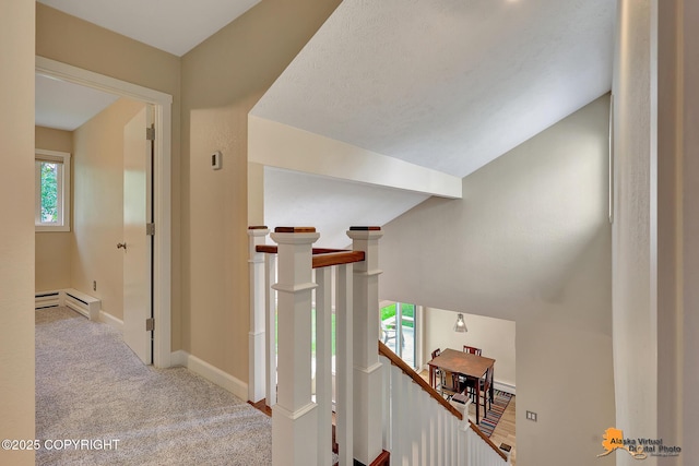 9606 Reliance Dr, Anchorage, AK 99507 - hallway featuring an upstairs landing, healthy amount of natural light, a baseboard heating unit, carpet flooring, and vaulted ceiling