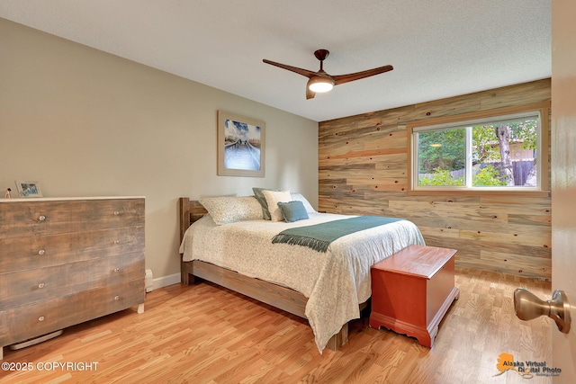 9606 Reliance Dr, Anchorage, AK 99507 - bedroom with wooden walls, wood finished floors, ceiling fan, and an accent wall