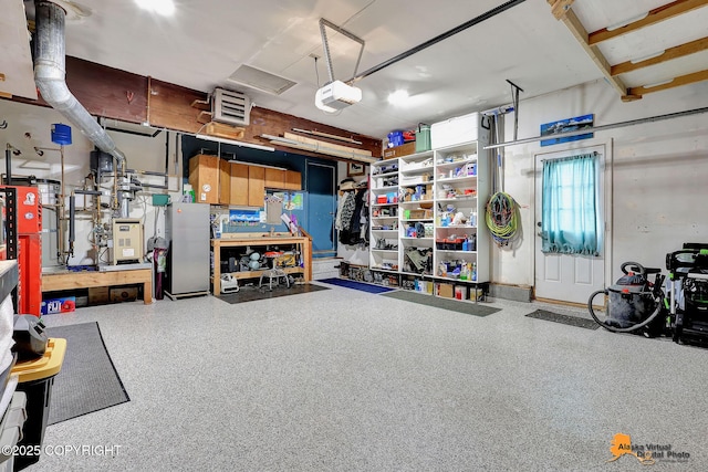 9606 Reliance Dr, Anchorage, AK 99507 - garage with a garage door opener, a workshop area, and a heating unit
