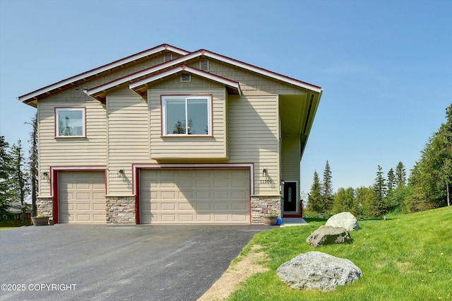 11300 Browder Ave, Anchorage, AK 99507 - view of front of home with stone siding, an attached garage, asphalt driveway, and a front lawn