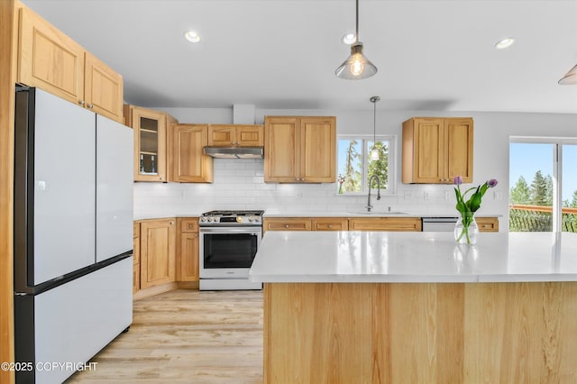 11300 Browder Ave, Anchorage, AK 99507 - kitchen featuring freestanding refrigerator, gas stove, light countertops, backsplash, and light wood-type flooring