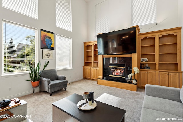 2439 Maritime Loop, Anchorage, AK 99515 - living area with light carpet, a towering ceiling, and a premium fireplace