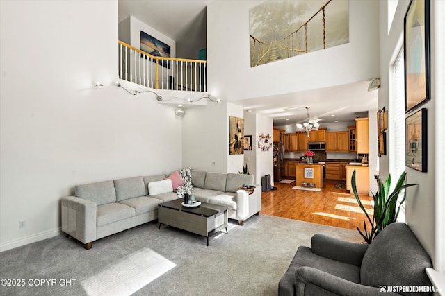 2439 Maritime Loop, Anchorage, AK 99515 - living area with a chandelier, a towering ceiling, light wood-style flooring, and light carpet