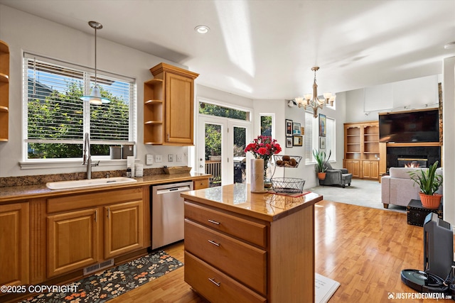 2439 Maritime Loop, Anchorage, AK 99515 - kitchen with stainless steel dishwasher, open shelves, light wood-style flooring, a center island, and a fireplace