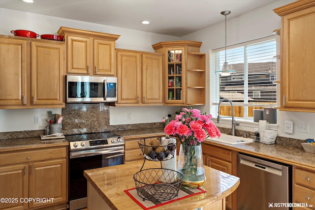 2439 Maritime Loop, Anchorage, AK 99515 - kitchen with stainless steel appliances, hanging light fixtures, glass insert cabinets, recessed lighting, and decorative backsplash
