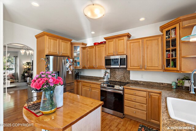2439 Maritime Loop, Anchorage, AK 99515 - kitchen with appliances with stainless steel finishes, light wood-style flooring, glass insert cabinets, recessed lighting, and backsplash