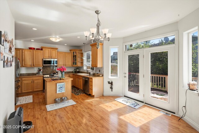 2439 Maritime Loop, Anchorage, AK 99515 - kitchen with appliances with stainless steel finishes, healthy amount of natural light, a kitchen island, light wood-style floors, and recessed lighting