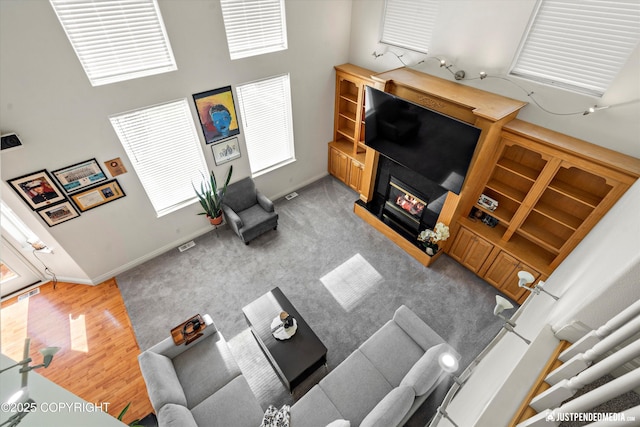 2439 Maritime Loop, Anchorage, AK 99515 - living area with a high ceiling, a glass covered fireplace, and wood finished floors