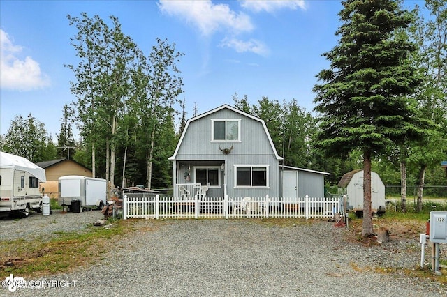 45552 Spruce Ave # 123, Soldotna, AK 99669 - colonial inspired home featuring a storage shed, a gambrel roof, and view of wooded area