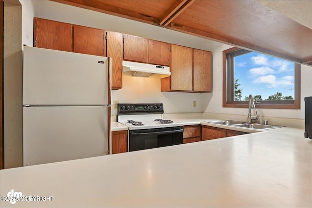 3681 E 20th Ave, Anchorage, AK 99508 - kitchen with freestanding refrigerator, electric stove, under cabinet range hood, light countertops, and brown cabinets
