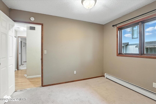 3681 E 20th Ave, Anchorage, AK 99508 - spare room with a baseboard heating unit, light colored carpet, a textured ceiling, and a smoke detector
