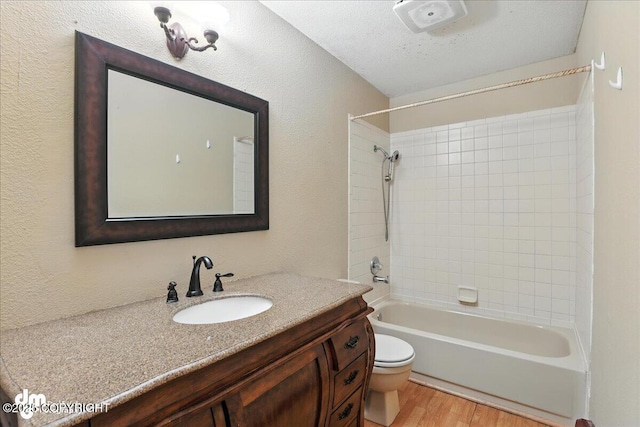3681 E 20th Ave, Anchorage, AK 99508 - full bathroom featuring wood finished floors, vanity, shower / tub combination, and a textured wall