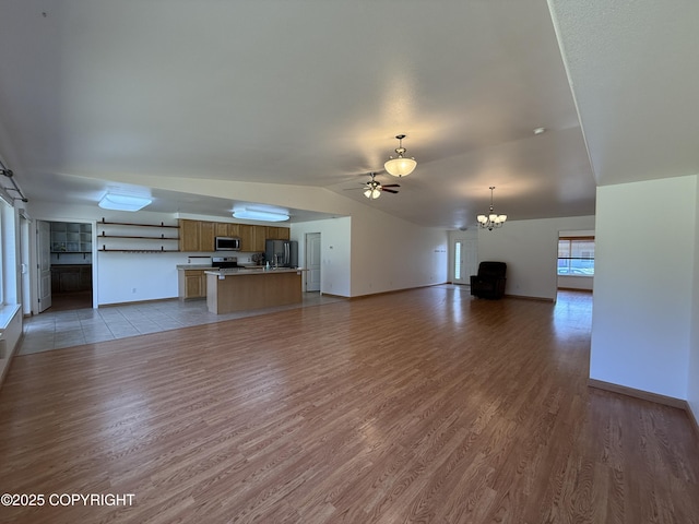 123 Green Valley St, Soldotna, AK 99669 - unfurnished living room featuring lofted ceiling, a chandelier, light wood-type flooring, and ceiling fan