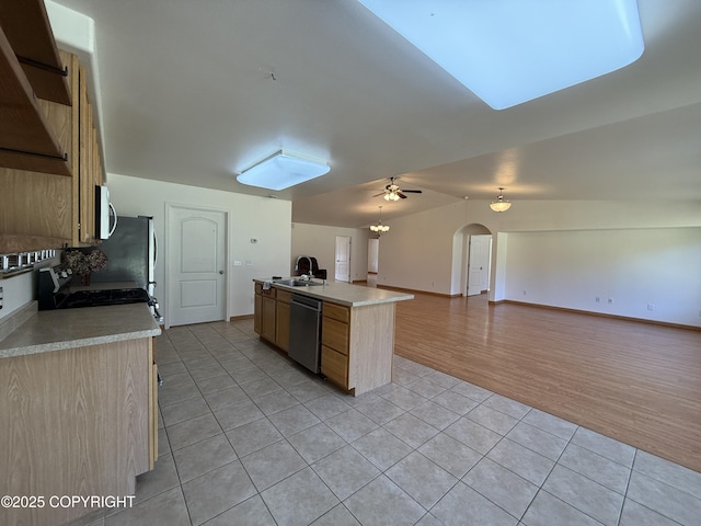 123 Green Valley St, Soldotna, AK 99669 - kitchen featuring stainless steel dishwasher, light tile patterned flooring, open floor plan, light countertops, and arched walkways
