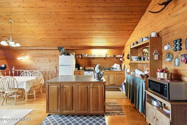 64320 Trail Rd, Anchor Point, AK 99556 - kitchen with stainless steel microwave, lofted ceiling, freestanding refrigerator, a chandelier, and light wood-type flooring