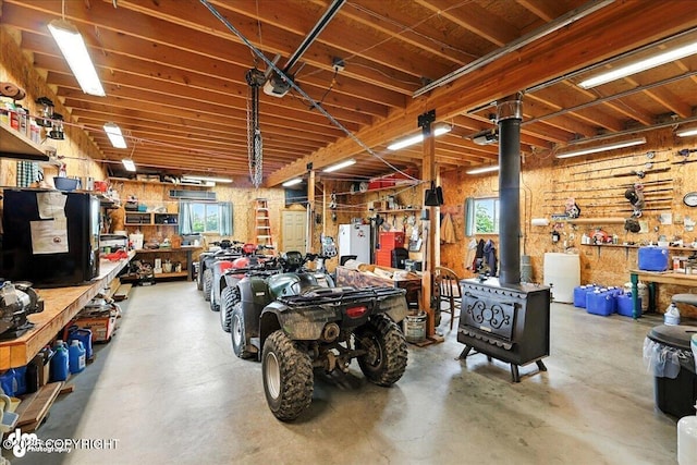 64320 Trail Rd, Anchor Point, AK 99556 - garage with a workshop area, a wood stove, and freestanding refrigerator