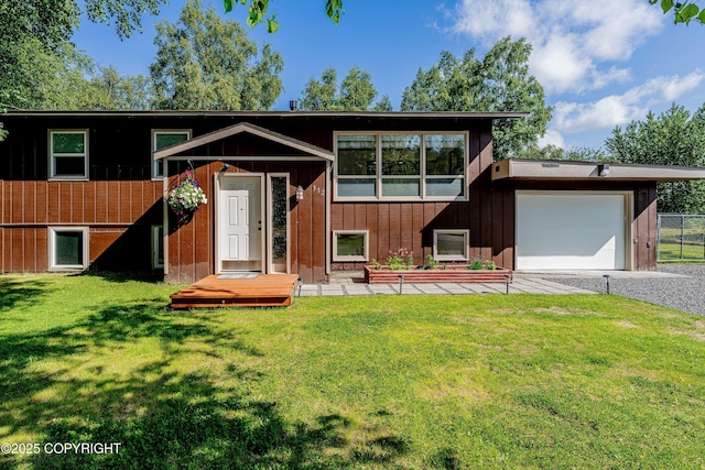 312 W Riverview Ave, Soldotna, AK 99669 - view of front of house featuring an attached garage, gravel driveway, a front lawn, and board and batten siding