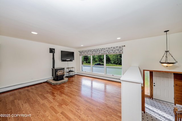 312 W Riverview Ave, Soldotna, AK 99669 - unfurnished living room featuring baseboard heating, a wood stove, light wood finished floors, and recessed lighting