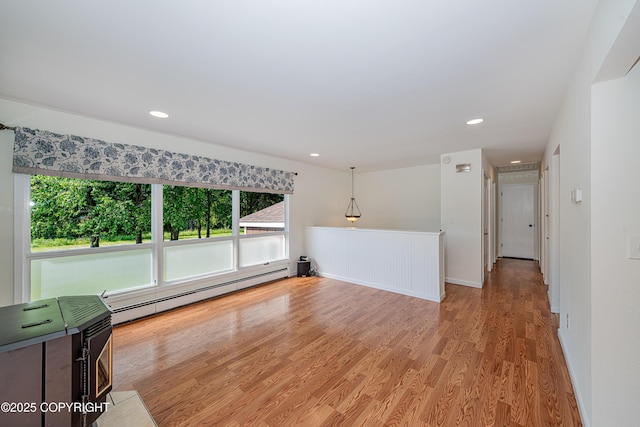 312 W Riverview Ave, Soldotna, AK 99669 - empty room featuring a baseboard radiator, plenty of natural light, wood finished floors, and recessed lighting