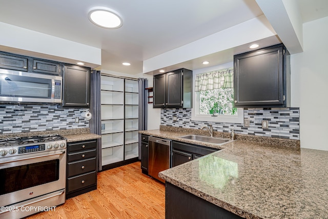 312 W Riverview Ave, Soldotna, AK 99669 - kitchen featuring appliances with stainless steel finishes, light wood-style flooring, and tasteful backsplash