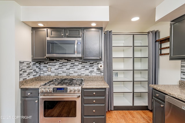 312 W Riverview Ave, Soldotna, AK 99669 - kitchen with stainless steel appliances, tasteful backsplash, light wood-type flooring, and gray cabinets