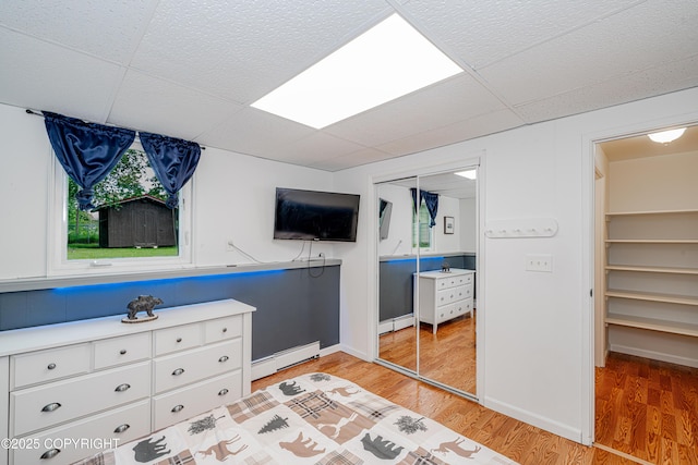 312 W Riverview Ave, Soldotna, AK 99669 - bedroom featuring a baseboard radiator, a paneled ceiling, and light wood finished floors