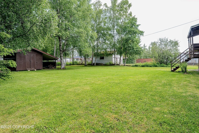 312 W Riverview Ave, Soldotna, AK 99669 - view of grassy yard with stairs and a storage shed