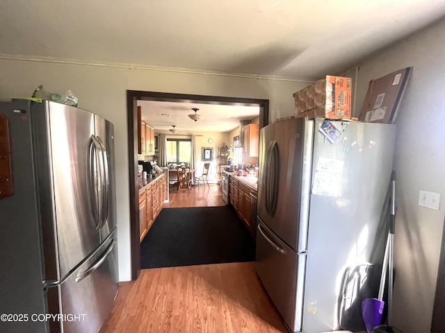 4002 Barbara Dr, Anchorage, AK 99517 - kitchen featuring freestanding refrigerator, wood finished floors, and brown cabinetry
