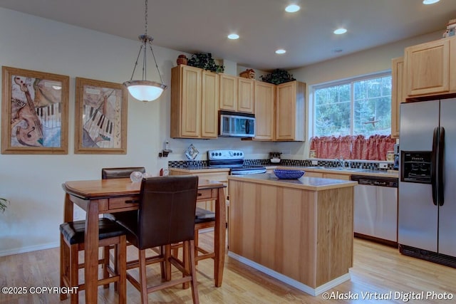 20103 Riverside Dr # 1B, Eagle River, AK 99577 - kitchen featuring appliances with stainless steel finishes, light brown cabinets, light wood-type flooring, recessed lighting, and a kitchen island