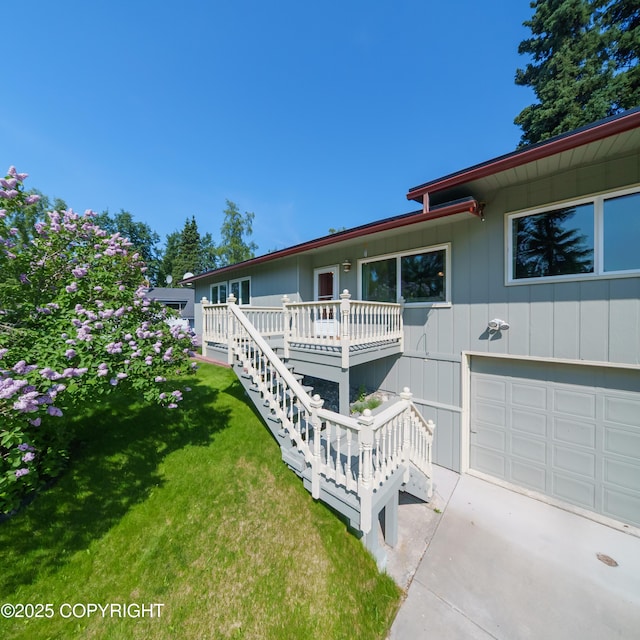 2831 Bennett Ave, Anchorage, AK 99517 - view of front of home with a front yard, a garage, concrete driveway, stairway, and a deck