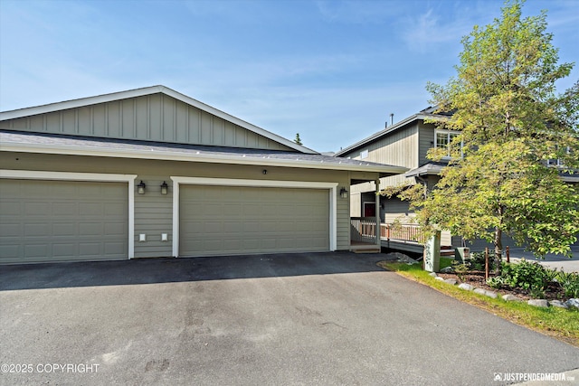 20218 Eagles Nest Ct, Eagle River, AK 99577 - view of front facade with asphalt driveway, board and batten siding, and a garage