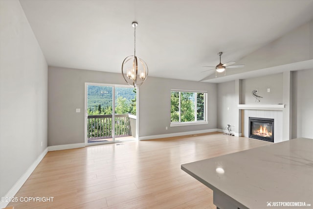 20218 Eagles Nest Ct, Eagle River, AK 99577 - unfurnished living room featuring healthy amount of natural light, a fireplace, ceiling fan, light wood finished floors, and lofted ceiling