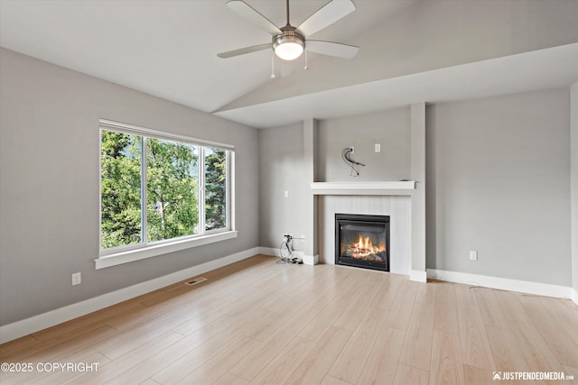 20218 Eagles Nest Ct, Eagle River, AK 99577 - unfurnished living room with a fireplace, vaulted ceiling, wood finished floors, and a ceiling fan