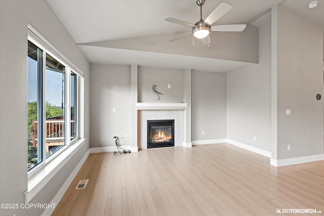 20218 Eagles Nest Ct, Eagle River, AK 99577 - unfurnished living room with lofted ceiling, a tiled fireplace, ceiling fan, and wood finished floors