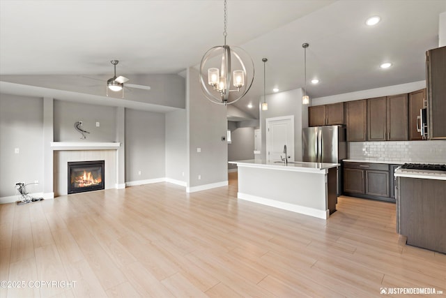 20218 Eagles Nest Ct, Eagle River, AK 99577 - kitchen with ceiling fan, vaulted ceiling, open floor plan, dark brown cabinetry, and stainless steel appliances