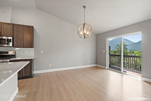 20218 Eagles Nest Ct, Eagle River, AK 99577 - kitchen with appliances with stainless steel finishes, vaulted ceiling, a chandelier, light countertops, and tasteful backsplash