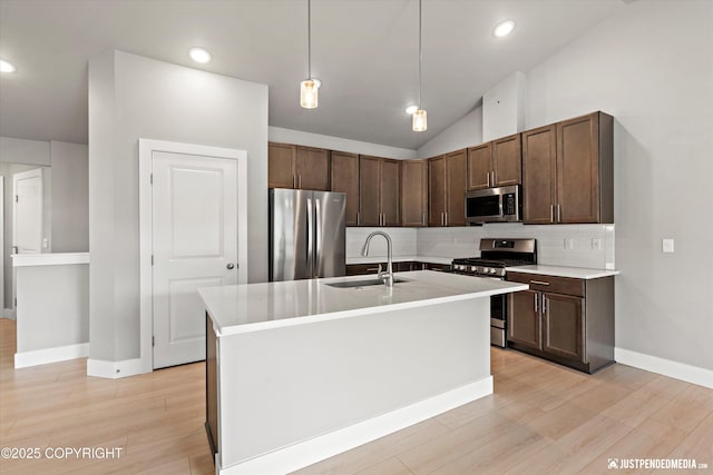 20218 Eagles Nest Ct, Eagle River, AK 99577 - kitchen with stainless steel appliances, decorative backsplash, light countertops, light wood finished floors, and lofted ceiling