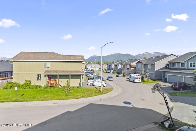 6218 Ophir Dr, Anchorage, AK 99504 - view of asphalt road with a residential view, curbs, a mountain view, and street lighting