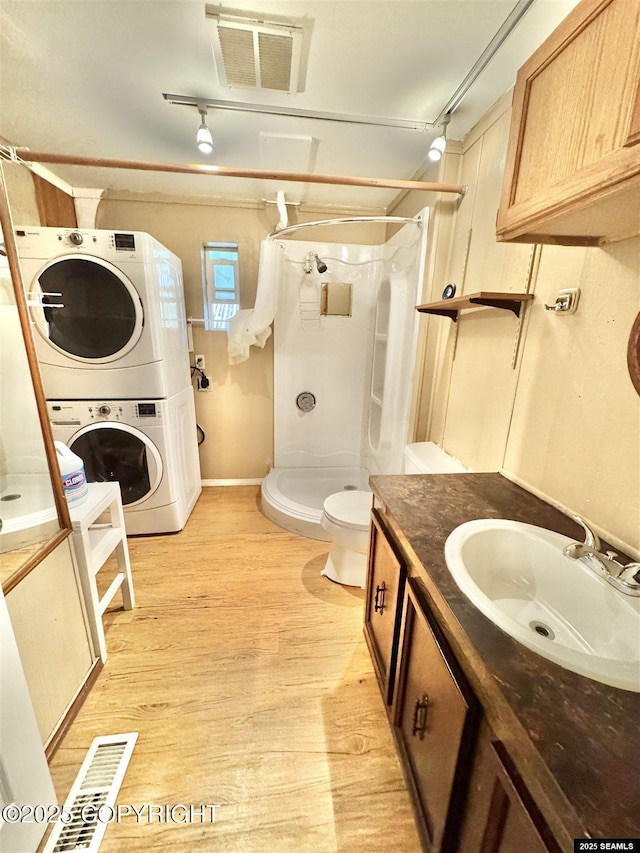 6590 Glacier Hwy, Juneau, AK 99801 - full bathroom featuring stacked washer / drying machine, vanity, a stall shower, and wood finished floors