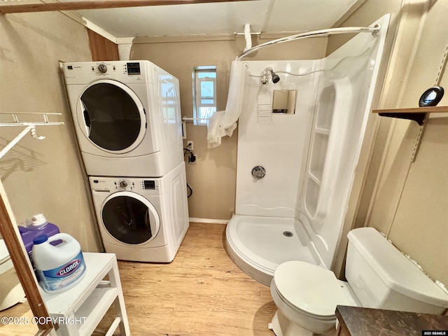 6590 Glacier Hwy, Juneau, AK 99801 - full bathroom featuring estacked washer and dryer, a stall shower, wood finished floors, and ornamental molding