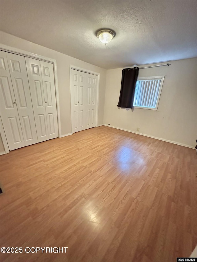 6590 Glacier Hwy, Juneau, AK 99801 - unfurnished bedroom featuring multiple closets, wood finished floors, and a textured ceiling