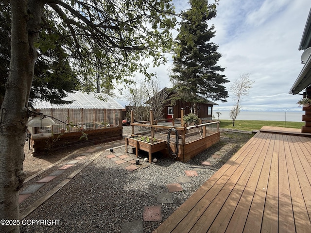 35605 Kalifornsky Beach Rd, Kenai, AK 99669 - wooden terrace featuring a greenhouse, a vegetable garden, and an outdoor structure