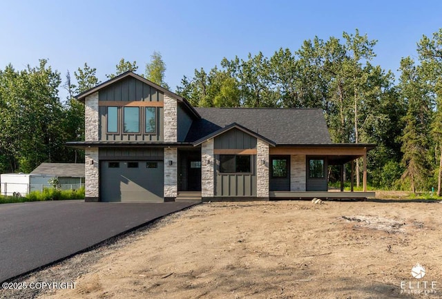 1401 E Holland Ave, Wasilla, AK 99654 - view of front facade with stone siding, board and batten siding, covered porch, a garage, and asphalt driveway