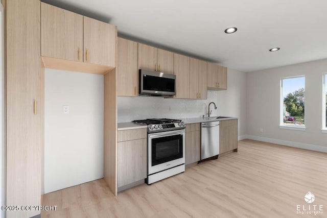 1401 E Holland Ave, Wasilla, AK 99654 - kitchen featuring appliances with stainless steel finishes, light brown cabinetry, light countertops, light wood-style flooring, and recessed lighting