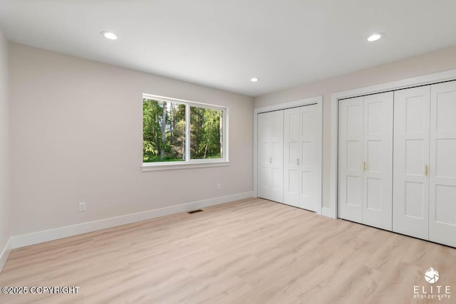 1401 E Holland Ave, Wasilla, AK 99654 - unfurnished bedroom featuring multiple closets, wood finished floors, and recessed lighting