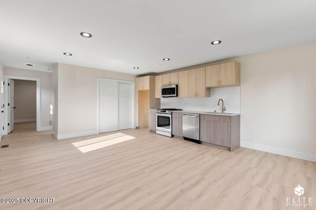 1401 E Holland Ave, Wasilla, AK 99654 - kitchen with appliances with stainless steel finishes, light brown cabinets, light wood-type flooring, recessed lighting, and light countertops