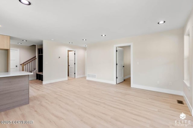 1401 E Holland Ave, Wasilla, AK 99654 - unfurnished living room with light wood-type flooring, stairs, and recessed lighting