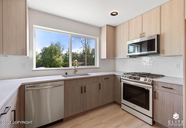1401 E Holland Ave, Wasilla, AK 99654 - kitchen featuring appliances with stainless steel finishes, light brown cabinets, light countertops, and tasteful backsplash