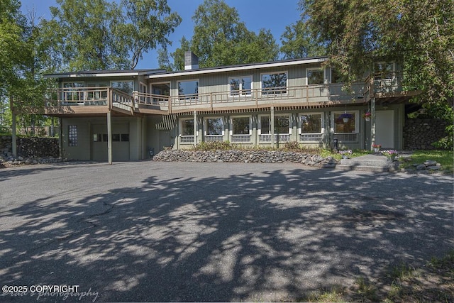 15021 Old Seward Hwy, Anchorage, AK 99516 - view of front facade featuring an attached garage, a chimney, asphalt driveway, and a wooden deck