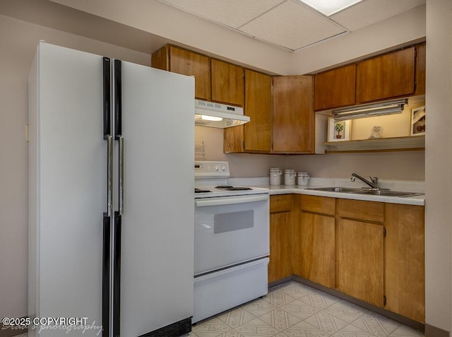 15021 Old Seward Hwy, Anchorage, AK 99516 - kitchen with white appliances, under cabinet range hood, light countertops, and brown cabinetry